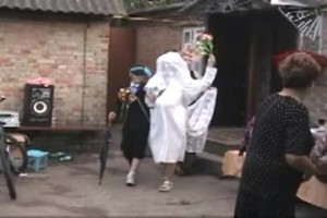 A cross dressed couple is introduced as the newlyweds. They start dancing and doing funny things.